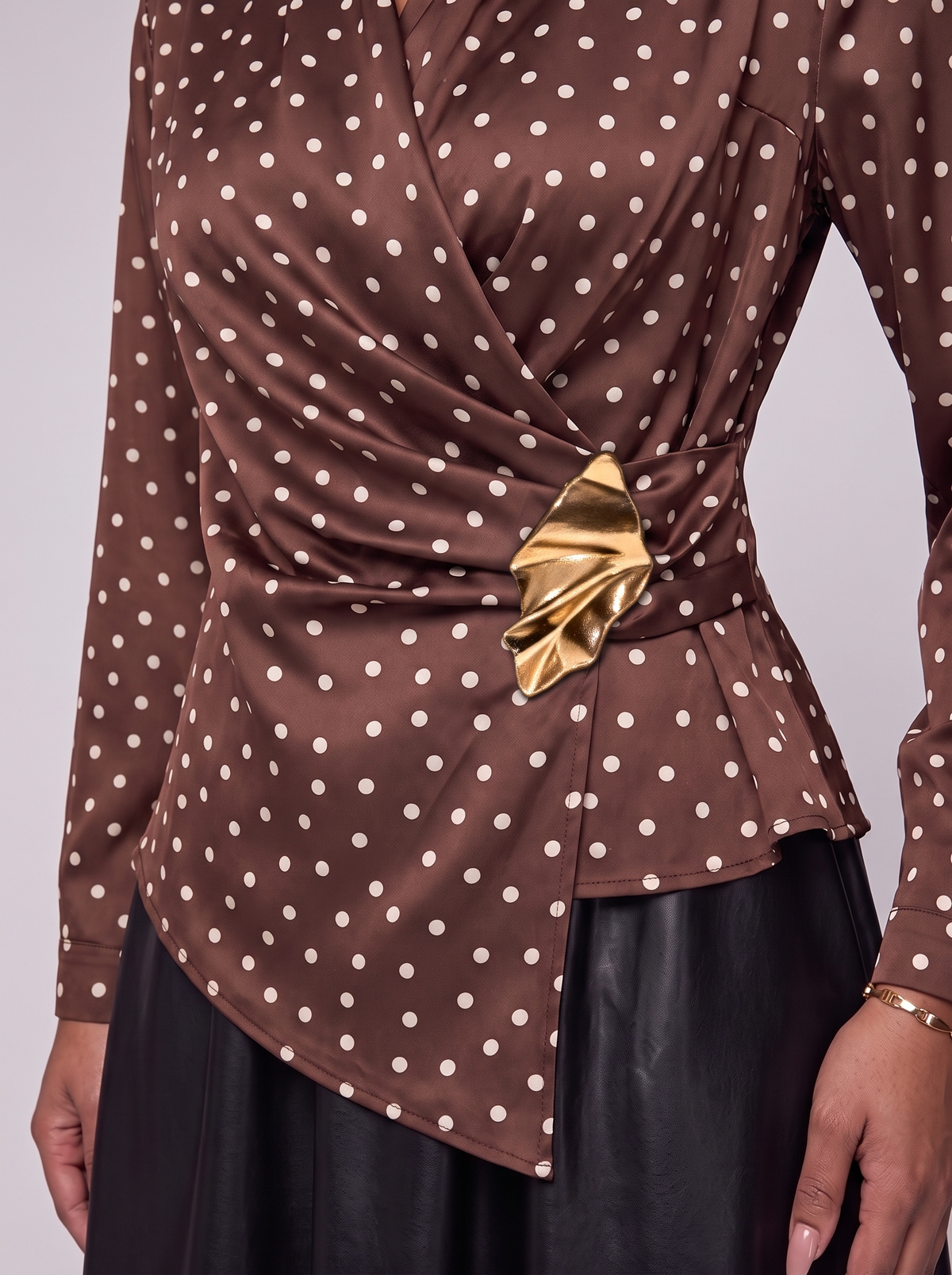 Lisette detail gouden broche aan de taille